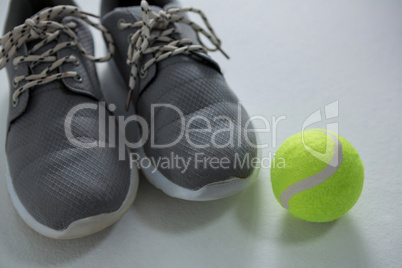Close up of sports shoes with tennis ball