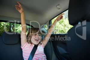 Teenage girl sitting in the back seat of car