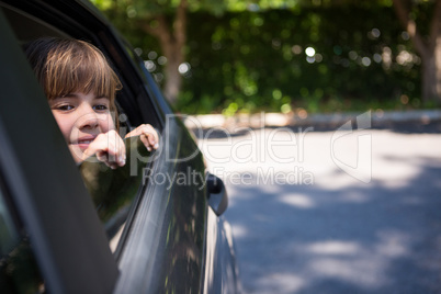 Teenage girl looking through car window