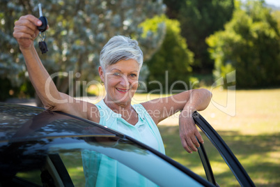 Senior woman holding a car key in park
