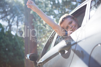 Teenage boy looking from open car window