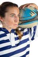 Close up of female athlete holding rugby ball while looking away