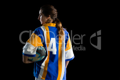 Rear view of female player holding rugby ball