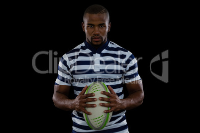 Portrait of serious male player holding rugby ball