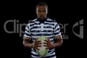 Portrait of serious male player holding rugby ball
