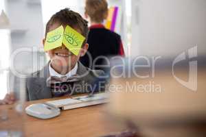 Boy as business executive with sticky notes on his eyes