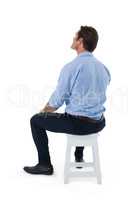 Male executive sitting on stool