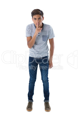 Portrait of teenage boy with finger on lips