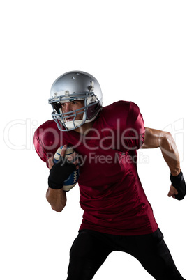 Focused football player wearing helmet holding ball while playing