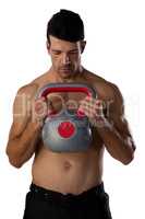 Focused sports player exercising with kettle bell