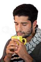 Man smelling a mug of coffee against white background