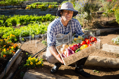 Portrait of happy man holding a basket of fresh vegetables