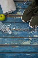 Directly above view of sports shoes and napkin by headphones with water bottle