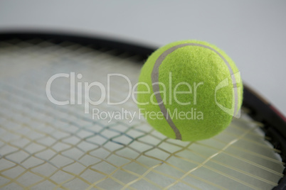 Close up of fluorescent tennis ball on racket