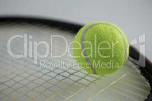 Close up of fluorescent tennis ball on racket