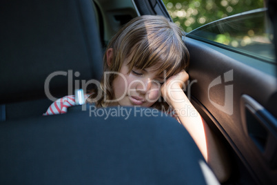Teenage girl sleeping in the back seat of car