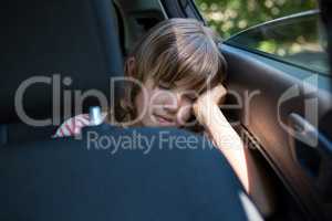 Teenage girl sleeping in the back seat of car