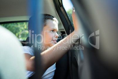 Teenage boy sitting in the back seat of car