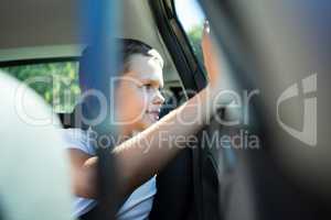 Teenage boy sitting in the back seat of car
