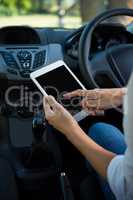 Woman using digital tablet in the car