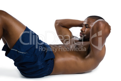 Shirtless male athlete practicing sit ups