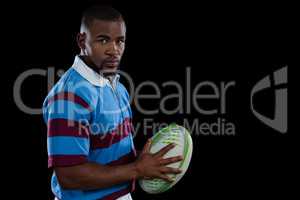 Portrait of confident male player holding rugby ball