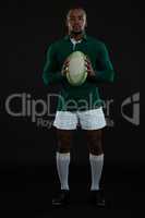 Portrait of young male rugby player holding ball