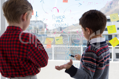 Kids as business executives discussing over whiteboard