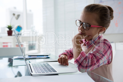 Girl as business executive using laptop while sitting