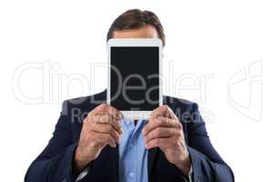 Businessman hiding her face behind digital tablet