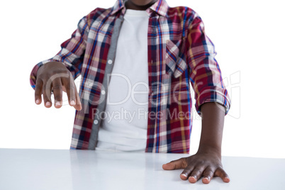 Boy pretending to work on an invisible object against white background