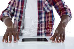 Boy trying to hold the digital tablet against white background