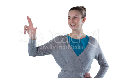 Smiling teenage girl pressing an invisible virtual screen