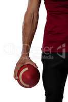 Cropped image of American football player holding ball