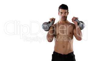 Portrait of shirtless sports player exercising with kettle bells