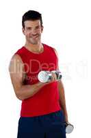 Portrait of smiling sports player exercising with dumbbells