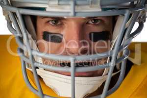 Close-up portrait of determined American football player wearing helmet