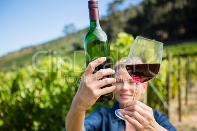 Female vintner examining wine