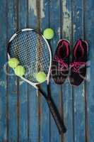 Overhead view of sports shoes with tennis racket and balls