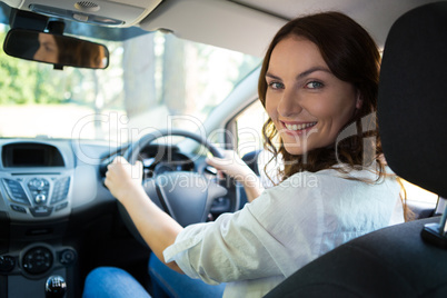 Beautiful smiling woman driving a car