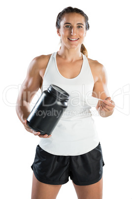 Portrait of happy female athlete taking supplement powder