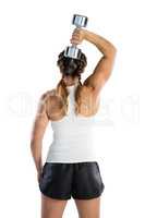 Rear view of female athlete lifting dumbbell