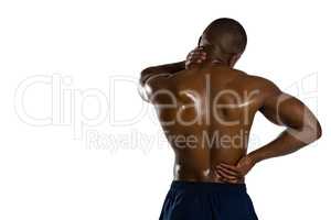 Rear view of shirtless sportsman suffering from pain