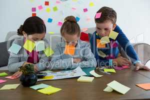 Kids as business executives playing with sticky notes