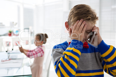 Boy as business executive talking on mobile phone