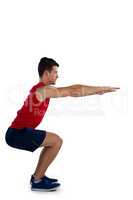 Side view of sports player exercising with arms outstretched while bending
