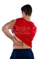 Rear view of American football player suffering from back pain