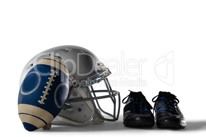 Close up of America football and helmet by sports shoes