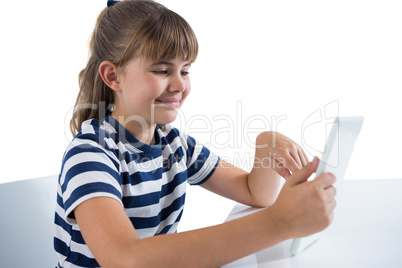 Cute girl using digital tablet at table