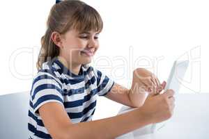 Cute girl using digital tablet at table